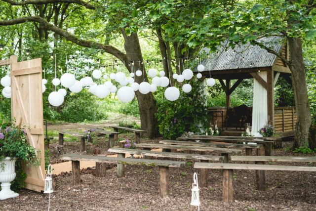 Outdoor ceremony area in the woodlands with benches and decorations